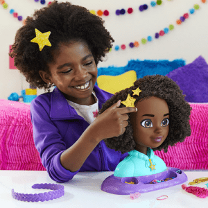 The Karma's World Styling head, with a little girl adding a star barette